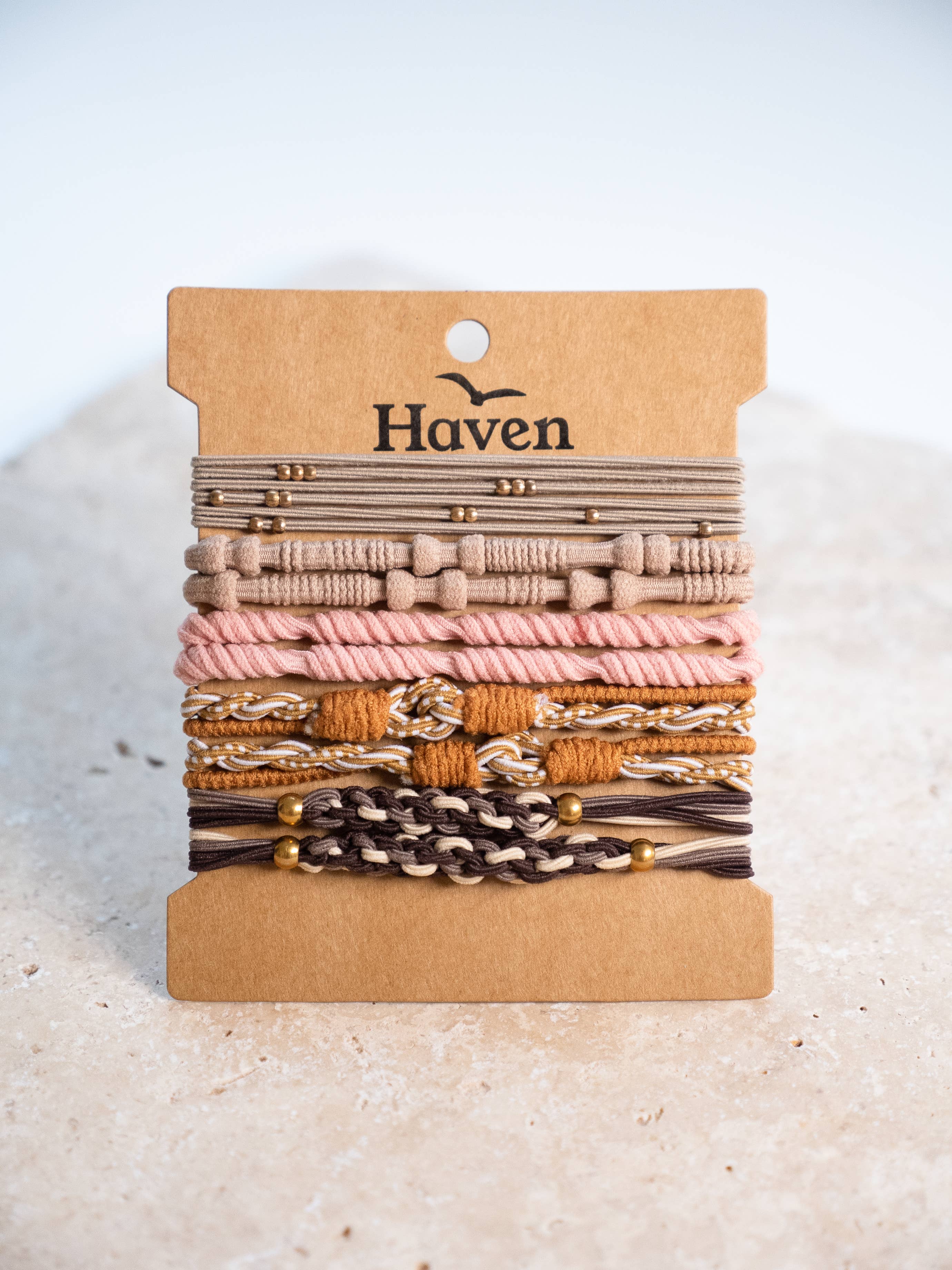 Set of bracelets/ hair ties on a cardboard holder with 'Haven' branding