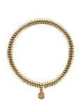 Gold beaded bracelet with a small round charm on a white background