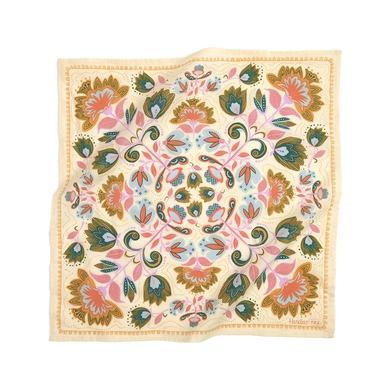 A cream-colored bandana with a floral pattern featuring teal, turquoise, orchid purple, canary yellow, and orange accents.