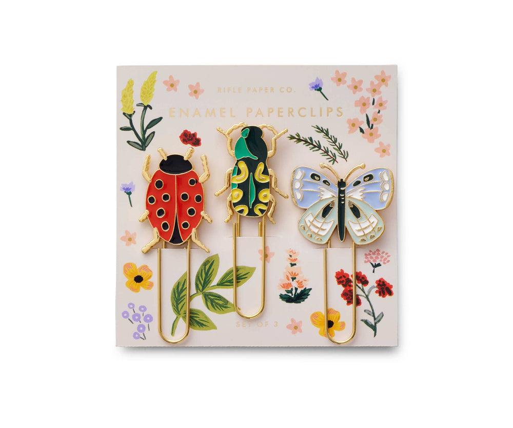 Set of paperclips shaped like a ladybug, frog, and butterfly on a decorative card with floral designs.