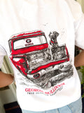 A white short-sleeve graphic t-shirt featuring a red vintage pickup truck with a black-and-white dog sitting in the bed, and 'GEORGIA BULLDOGS' printed below.