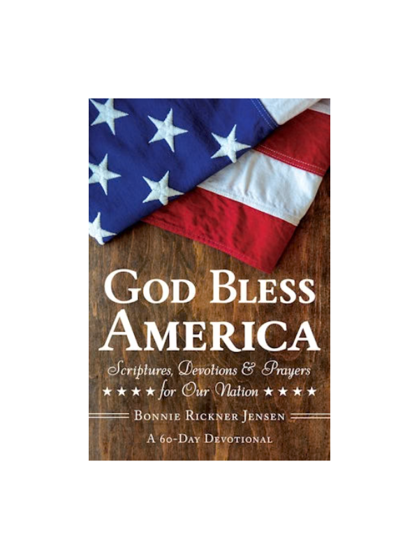 Book titled 'God Bless America' with an American flag on a wooden background