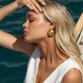 Woman with gold hammered clip on earrings 