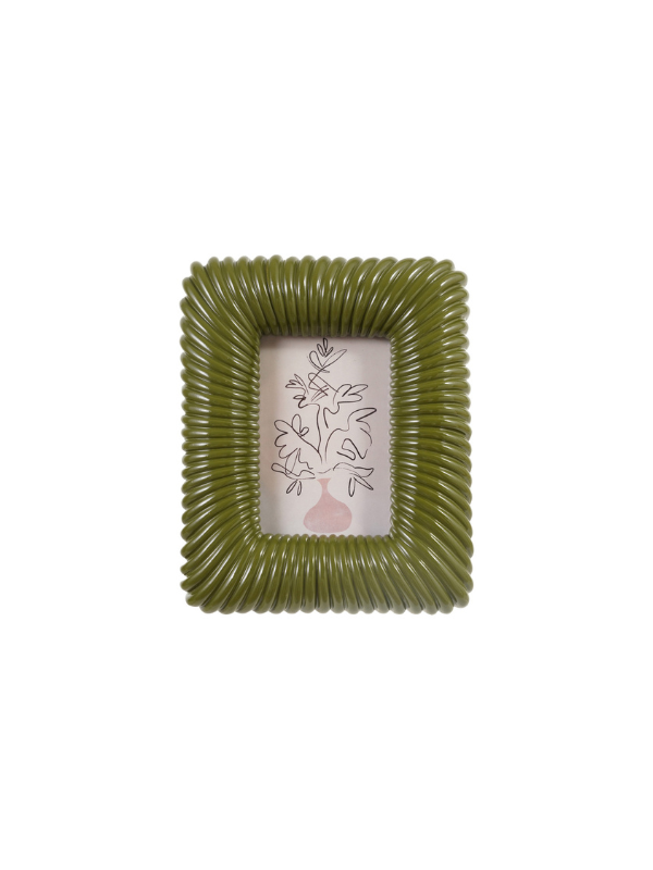 An olive green ribbed square picture frame with a white insert featuring a delicate black floral line drawing and a small pink vase at the bottom.