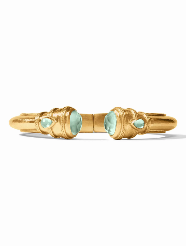 Gold bracelet with green gemstones on a white background