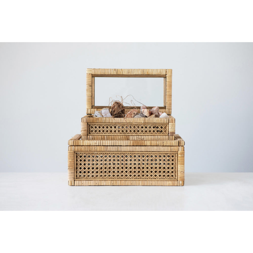 A large rattan storage box with a glass lid, displaying various items inside, placed against a neutral background.