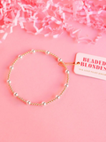 A gold-filled gold and silver beaded bracelet with elastic string