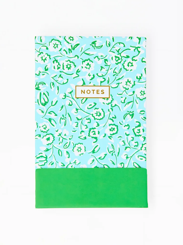 Notebook with floral pattern and green base on a white background