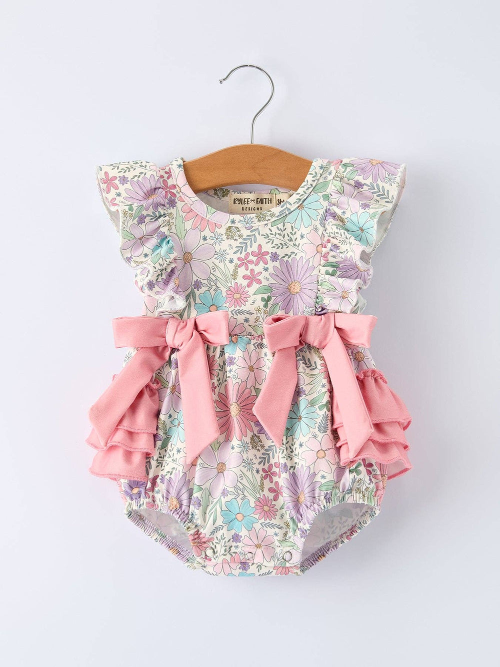 Floral baby romper with pink ruffles and bows
