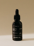 Black beard oil bottle with dropper on a beige background