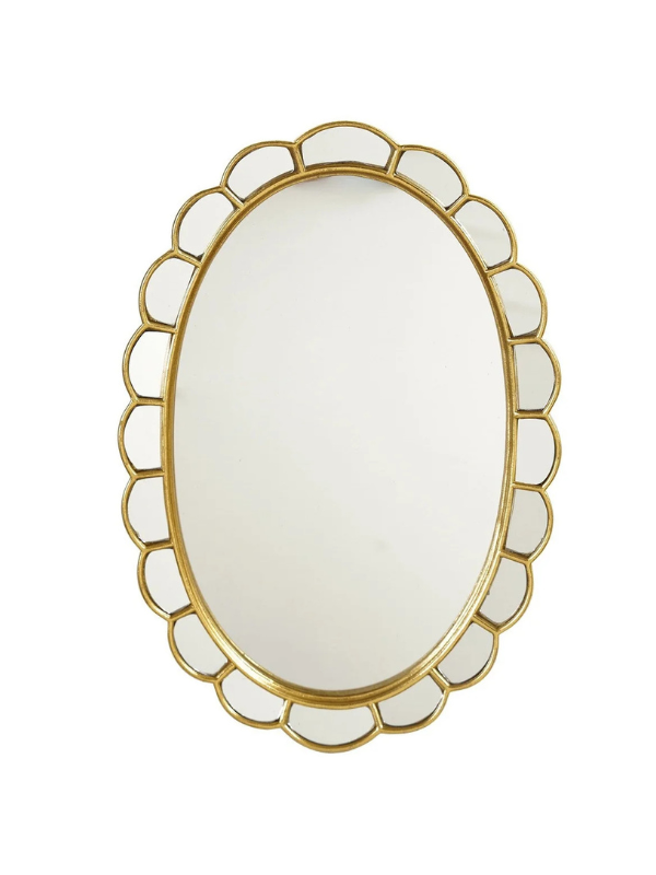 An oval wall mirror with a decorative gold scalloped metal frame