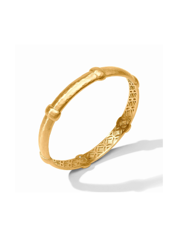 A gold hinged bangle bracelet with a textured, bamboo-inspired design and geometric patterns on the inner band