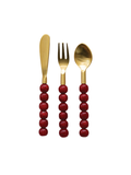 Three-piece gold-toned flatware set with red beaded handles, including a knife, fork, and spoon