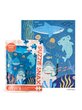 Workshop Snax kids' jigsaw puzzle featuring an underwater scene with a shark, dolphin, jellyfish, and sea plants, shown both assembled and in its retail packaging.