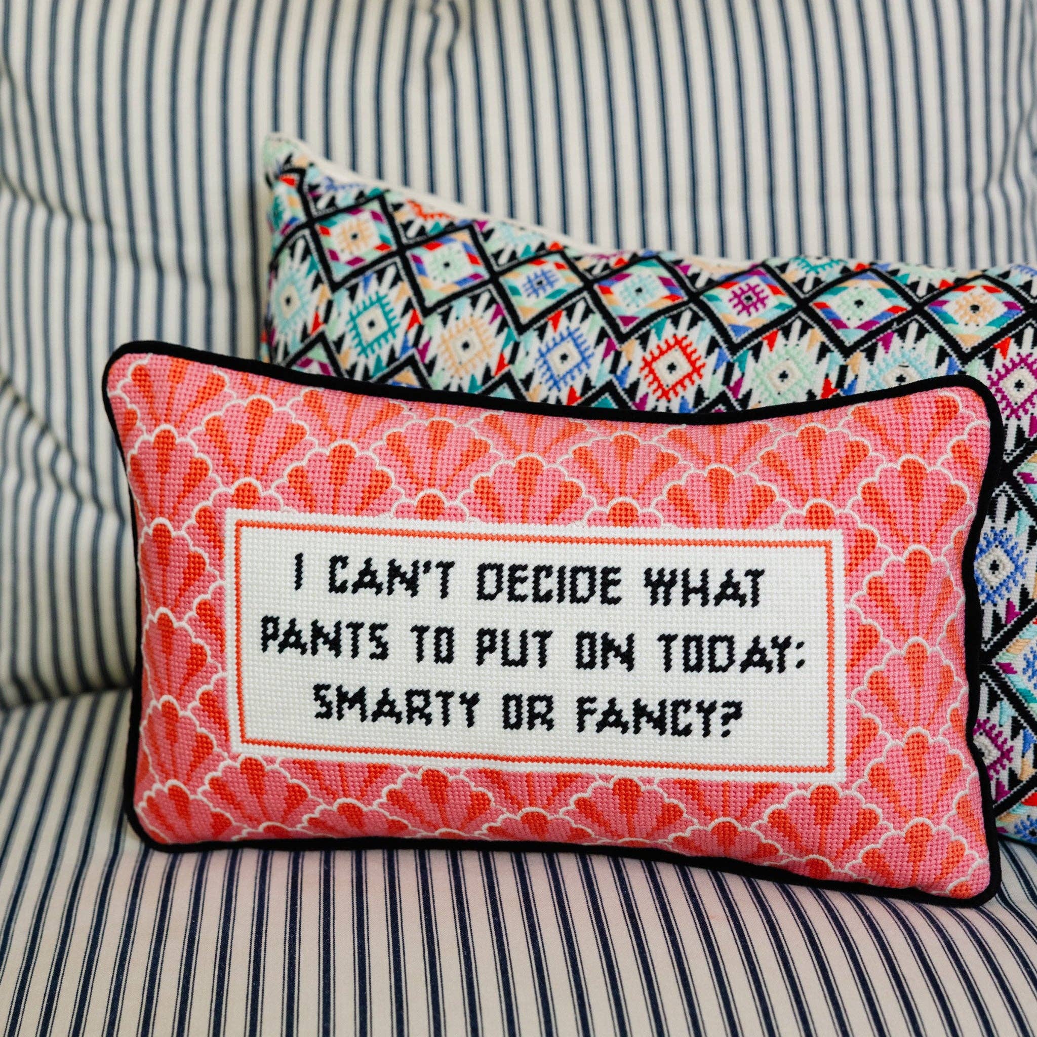 Decorative pillow with text on a striped couch