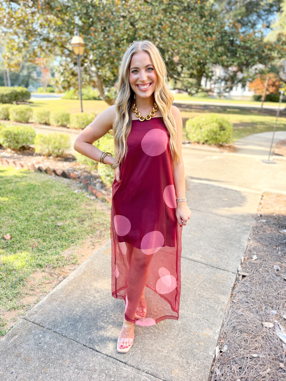 The maxi dress takes a classic polka dot and gives it a modern twist with oversized blush pink dots against a rich wine background.