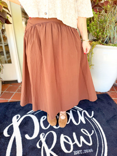  This rich brown maxi features a smooth fitted yoke that flows into a gathered, full silhouette for a flattering shape with plenty of movement. 
