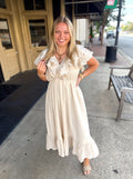 Cream-colored, tiered midi dress with ruffled short sleeves and a gathered waist. 