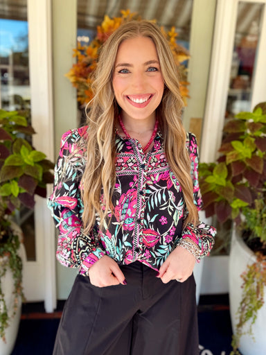 This black button-down top features a colorful botanical print in vibrant pink, mint, green, and soft neutral tones.