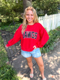 A red crewneck sweatshirt with 'DAWGS' printed across the chest in black and white lettering.  