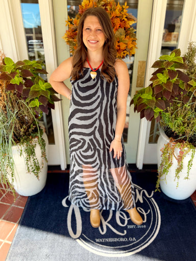 This black and gray zebra print maxi dress features a sleeveless design with a fitted, easy shape and sheer mesh detailing through the lower skirt.