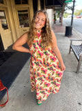 A sleeveless high-neck maxi dress with a vibrant pink, green, and orange floral pattern