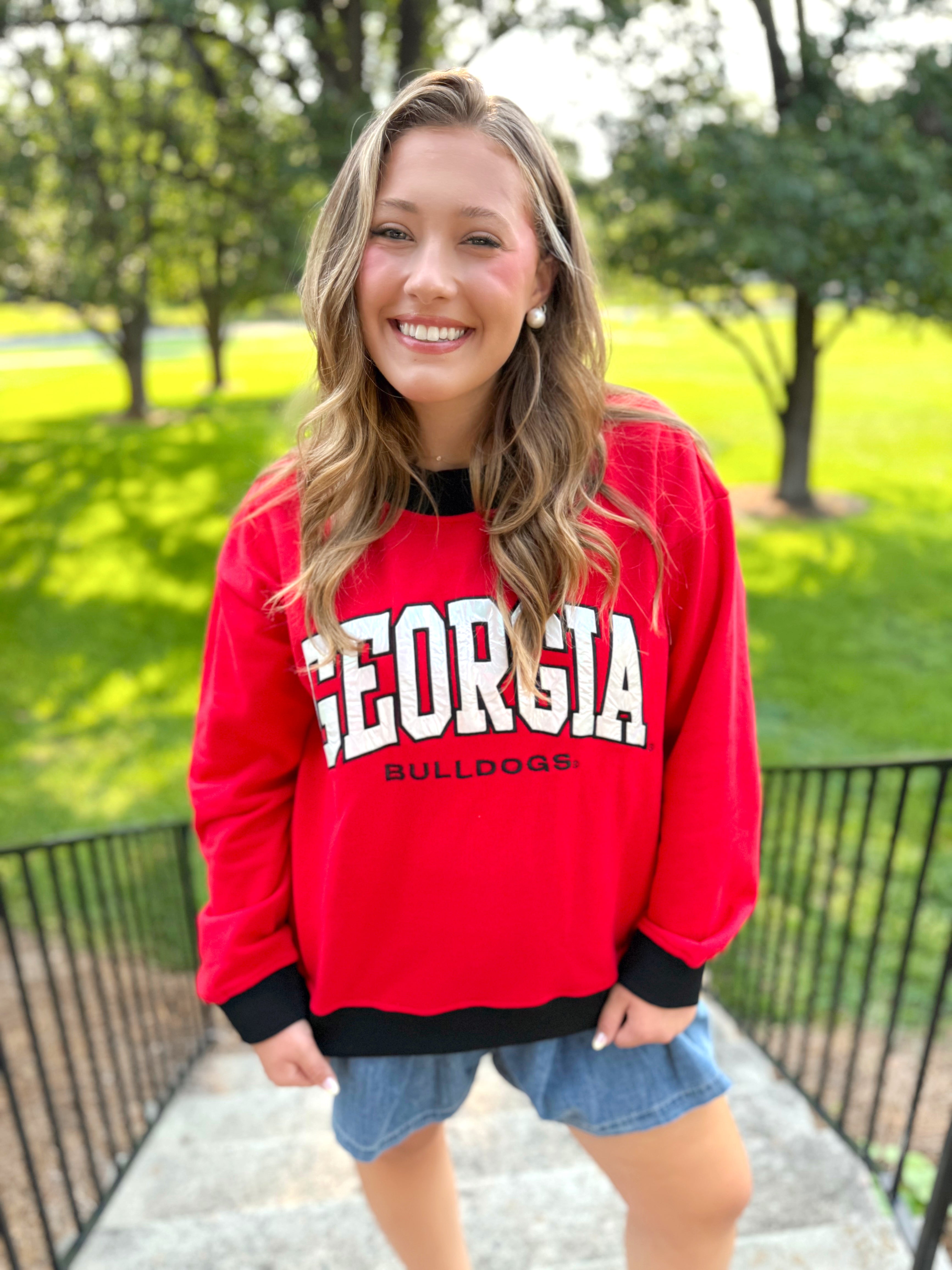 A red crewneck sweatshirt with 'GEORGIA BULLDOGS' printed in white and black.
