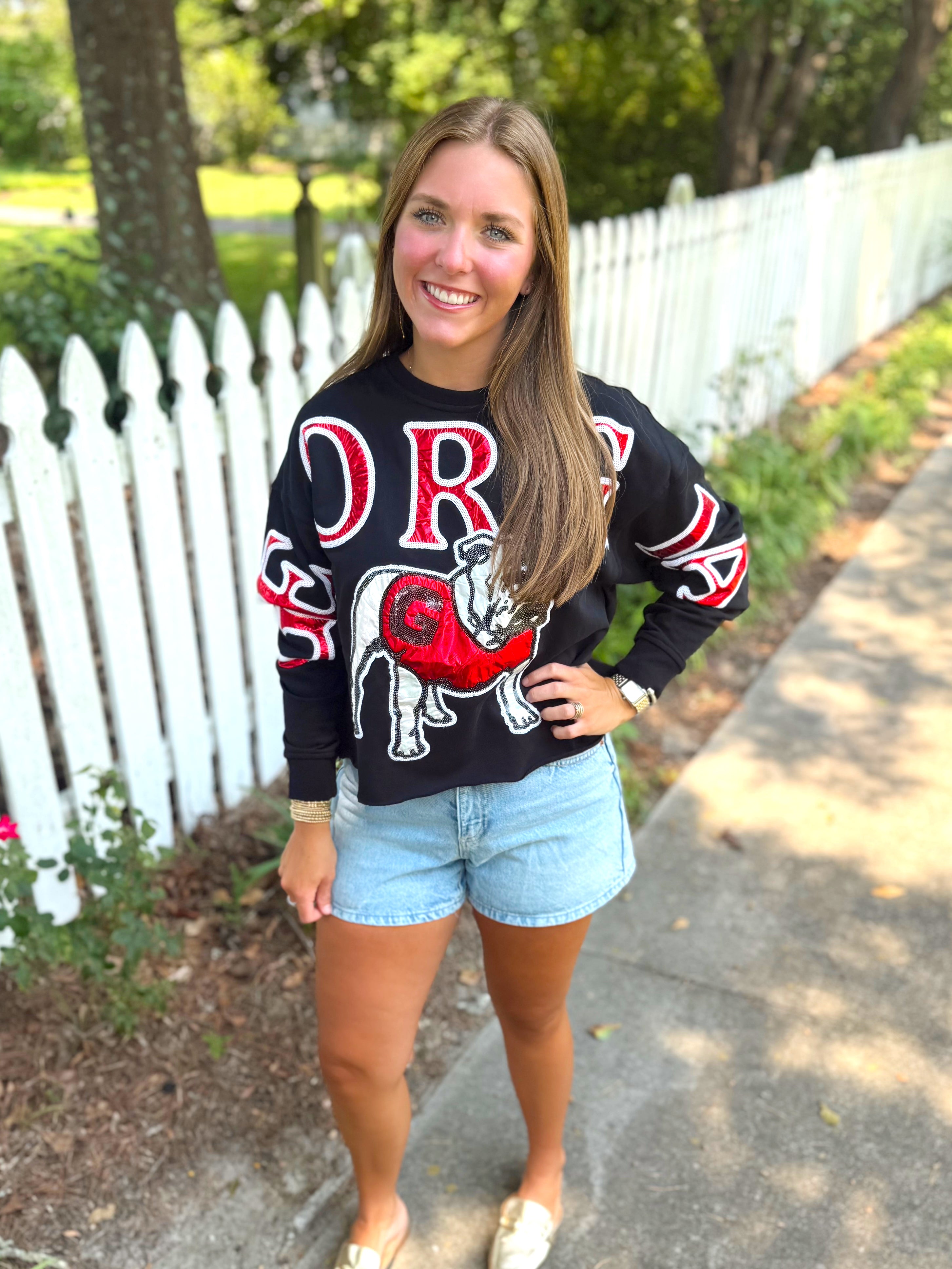 A black long-sleeve sweatshirt with a red and white graphic of a bulldog and the word 'GEORGIA' across the front