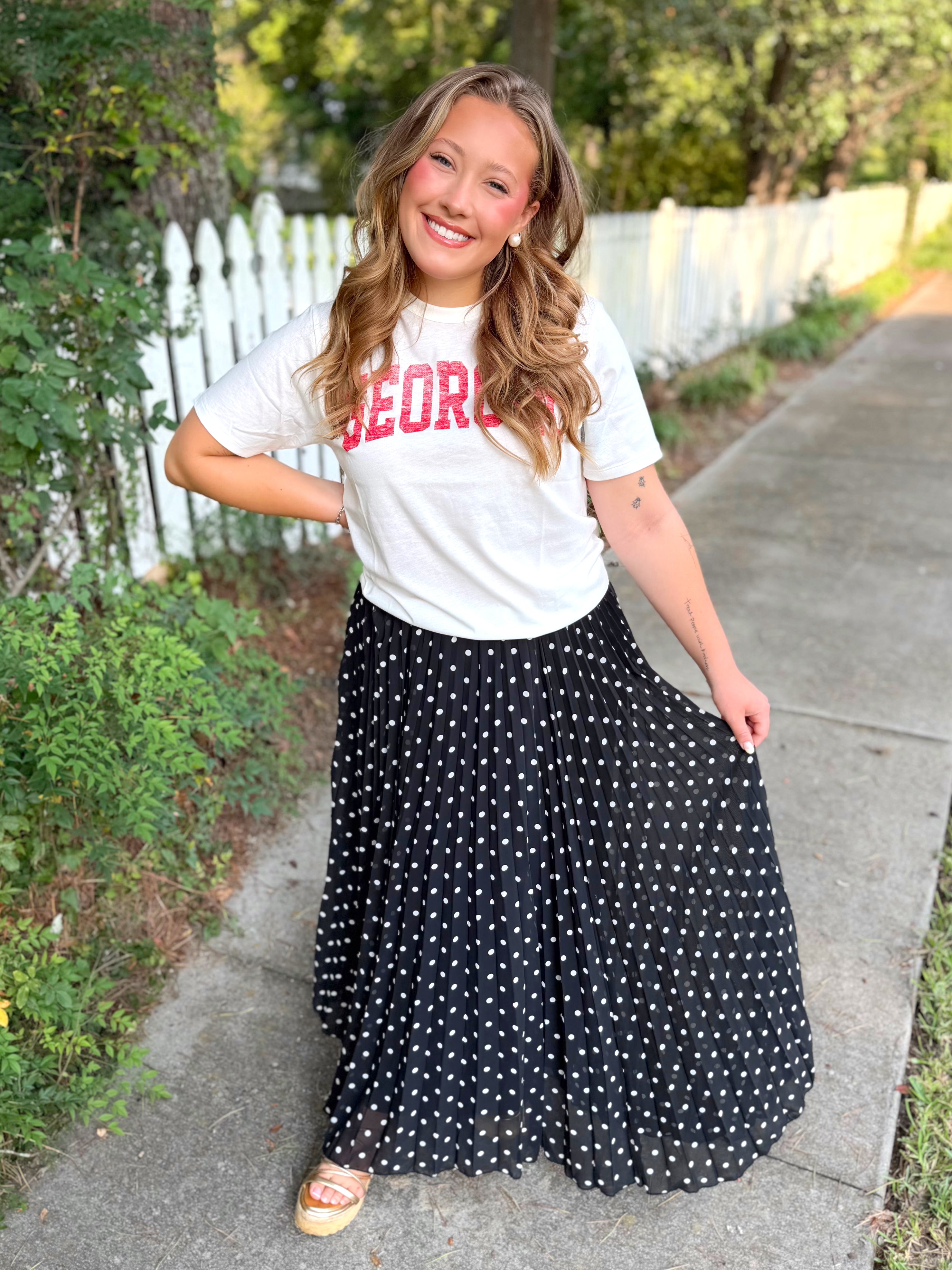 A white graphic T-shirt with red lettering that says "GEORGIA" across the chest