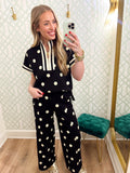 This polka dot top features a relaxed silhouette with a statement striped neckline, half-zip front, and matching striped trim at the sleeves
