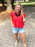 A red ruffled short-sleeve top with pleats down the front