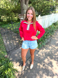 A red long-sleeve top with a white and black striped collar.
