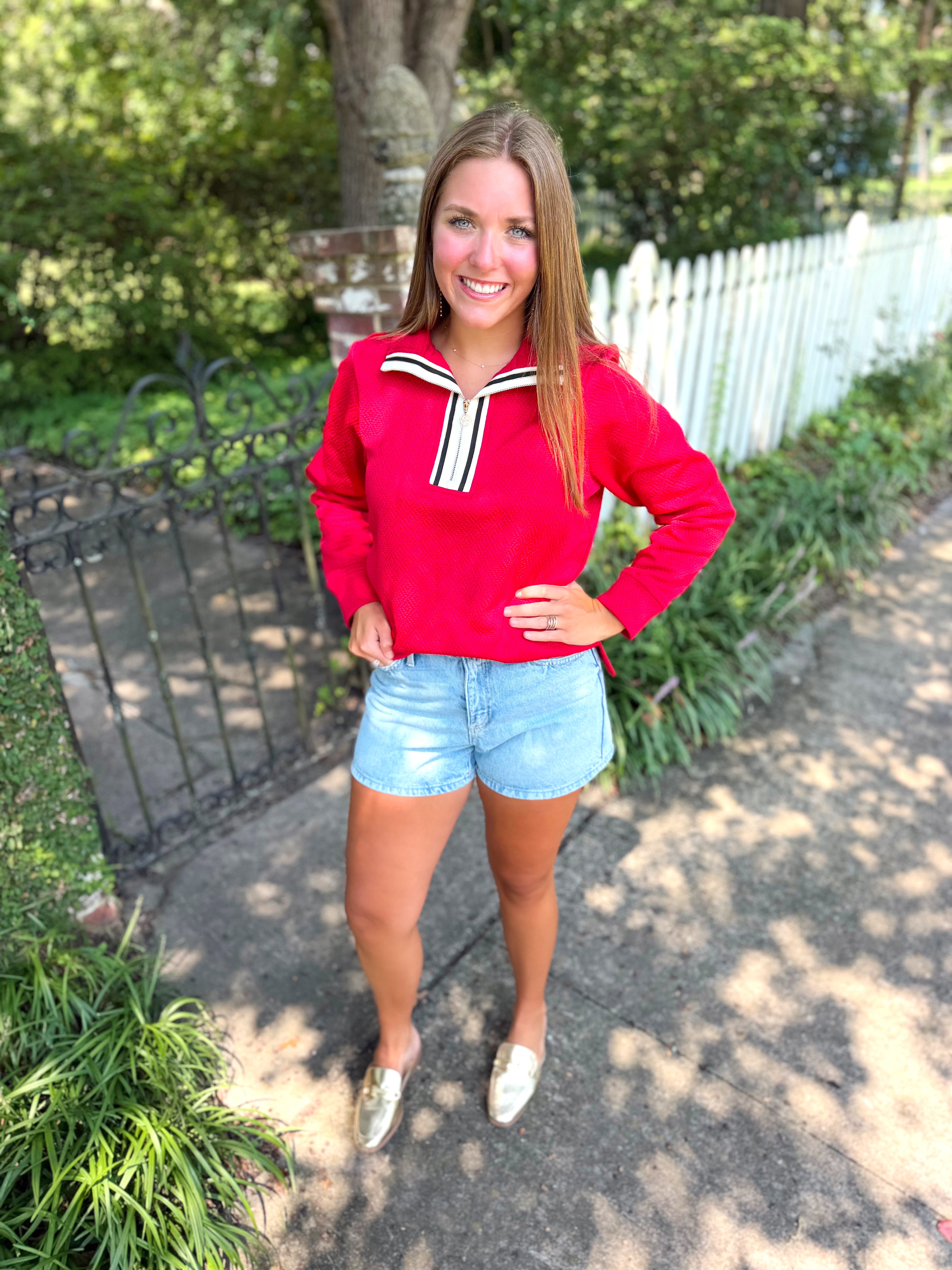 A red long-sleeve top with a white and black striped collar.