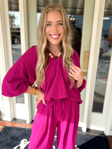 A bright fuchsia pink striped top with flowwy sleeves