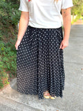 A black maxi skirt with white polka dots.