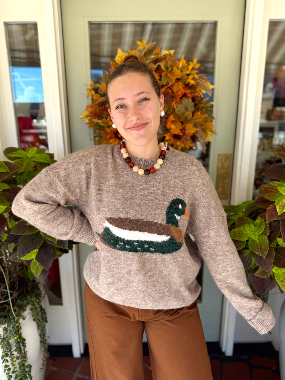 Brown sweater top with a green and brown mallard duck in the middle 