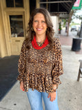 Leopard print long-sleeve blouse with a smocked bodice and ruffled hem.