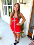 A red strapless mini dress with black and white trim details.