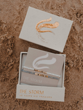 Bracelets in a box with 'The Storm' branding on a textured surface