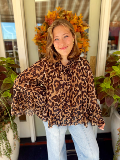  Featuring a classic animal print, tie neckline, and flowy silhouette, this top is finished with dramatic sleeves and a ruffled high-low hem for plenty of movement. 