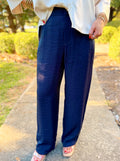 These pants feature a sleek navy finish with a subtle satin sheen, a flattering high-rise waist, and a relaxed straight-leg silhouette.