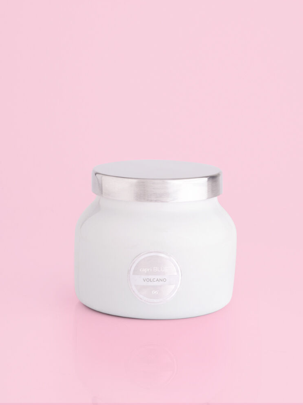 A volcano scented white candle jar with a silver lid by capri blue