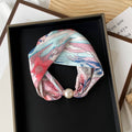 Decorative headband with floral design and pearl accent 