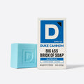 Blue bar of soap next to its packaging on a white background