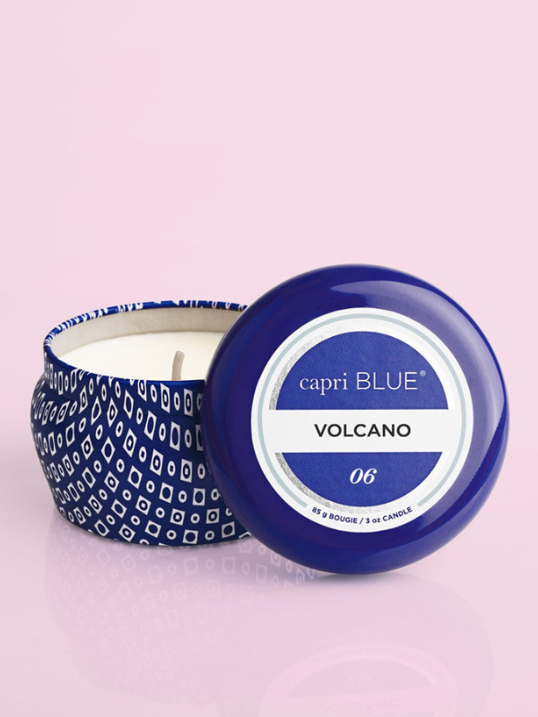 A volcano scented small blue tin candle with a lid featuring a white geometric pattern